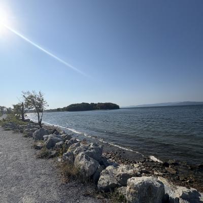The view of Lake Champlain, part of the road, and a small green island from the Causeway on the lake