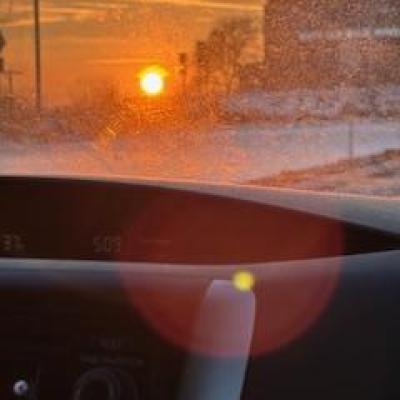 A golden evening sun radiating light through a car's window and onto the dashboard