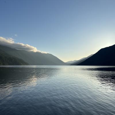 The sun rises over Crescent Lake, reflecting the mountains in the water.