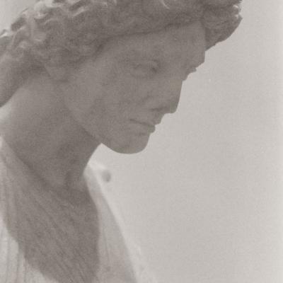 A close up black and white photo of a statue that I took in Italy, the angle is from a 3/4 view of the face and you can see a little bit of her dress 
