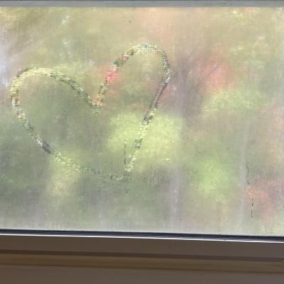 A fogged-up window with a heart drawn on the left side