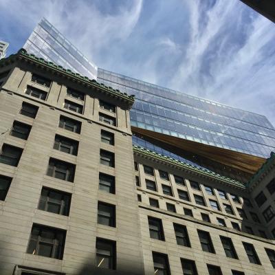 Bit of sky and clouds between tall buildings